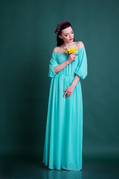 Söt flicka med krans av blommor i långa blå mode klä — Stockfoto