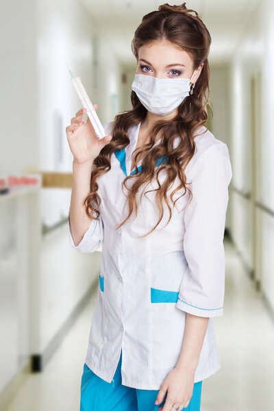 Young intern is practiced with syringe in hospital