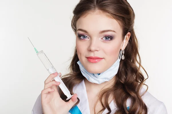 Молодая медсестра со шприцем на белом фоне — стоковое фото