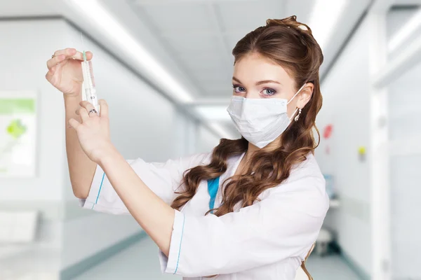 Young nurse with syringe in hospital hall — Stock Photo, Image