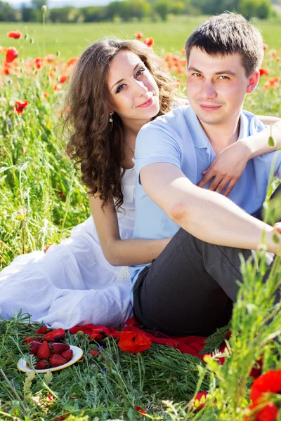 Chica feliz y niño en un prado lleno de amapolas — Foto de Stock