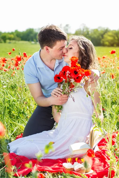 Chica y niño en un prado lleno de amapolas — Foto de Stock