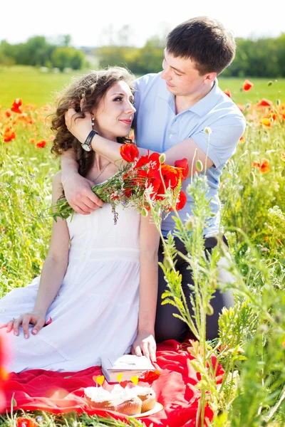 Menina feliz e menino em um prado cheio de papoulas — Fotografia de Stock