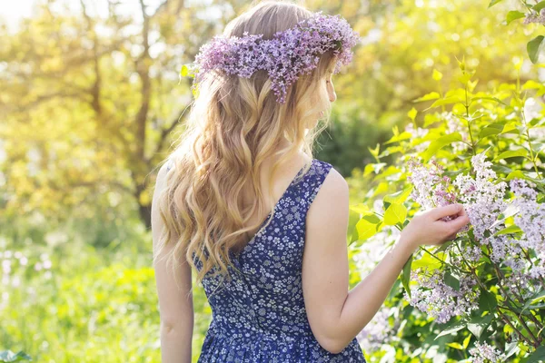 Mädchen mit fliederfarbenem Kranz im grünen Park — Stockfoto