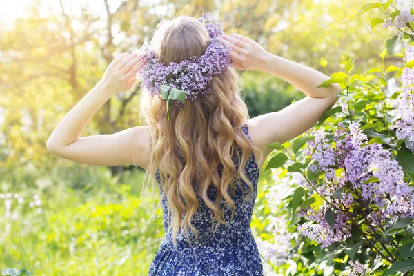 Chica con corona de flores de color lila en el parque verde — Foto de Stock