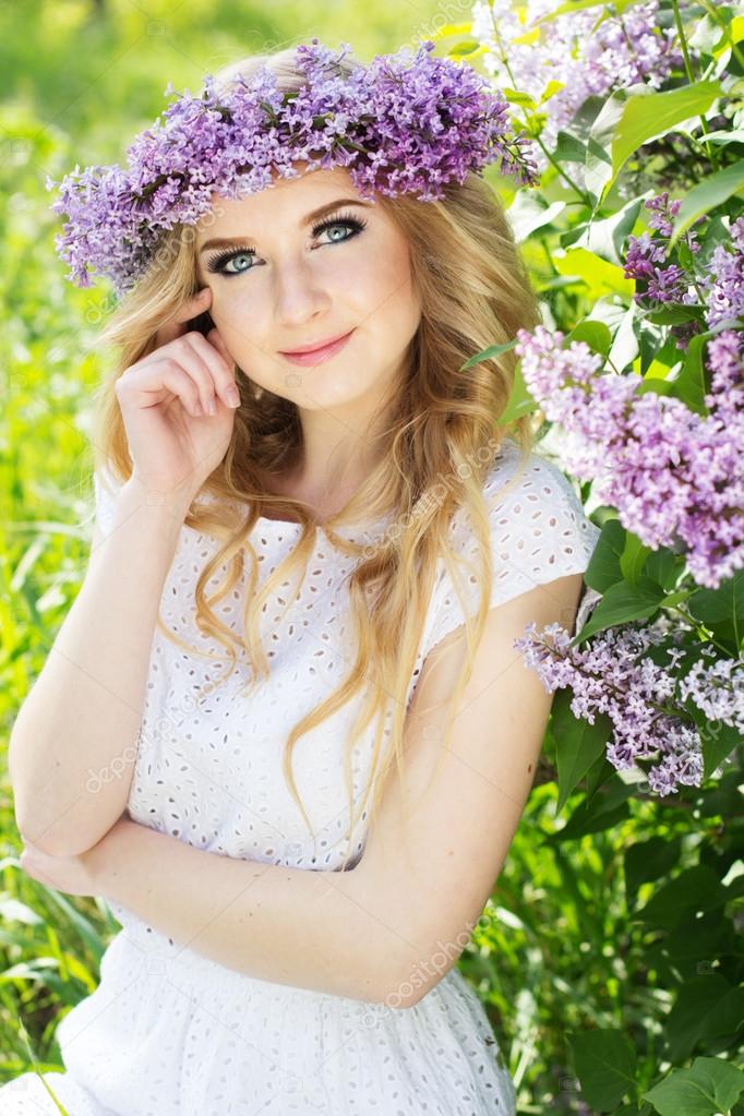 Portrait of beautiful girl with wreath from lilac flowers