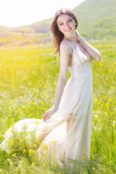 Vacker flicka i det gula fältet, sommartid — Stockfoto