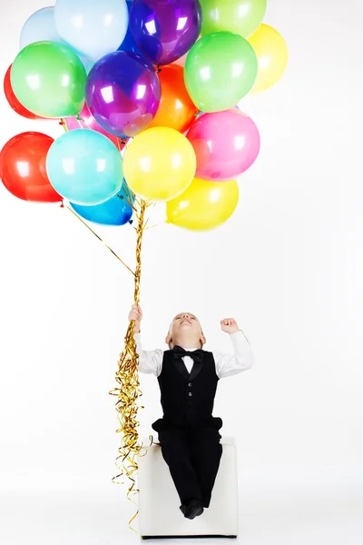 Pequeño niño feliz sosteniendo globos de colores —  Fotos de Stock