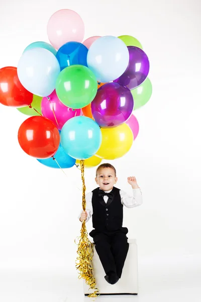 Niño sosteniendo globos de colores —  Fotos de Stock