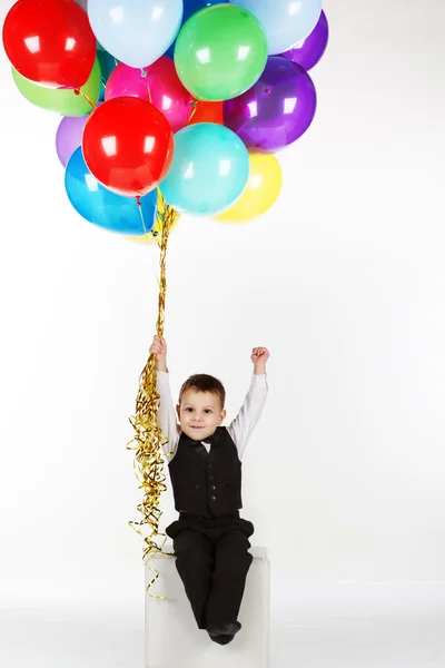 Niño sosteniendo globos de colores —  Fotos de Stock