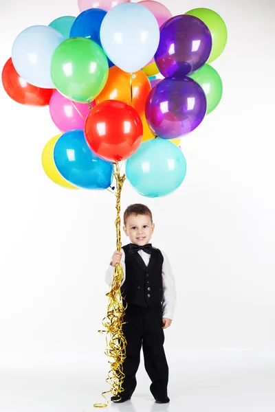 Niño sosteniendo globos de colores —  Fotos de Stock