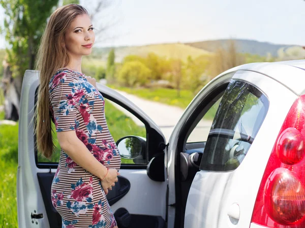 Glücklich schwangere Frau steht neben Auto — Stockfoto