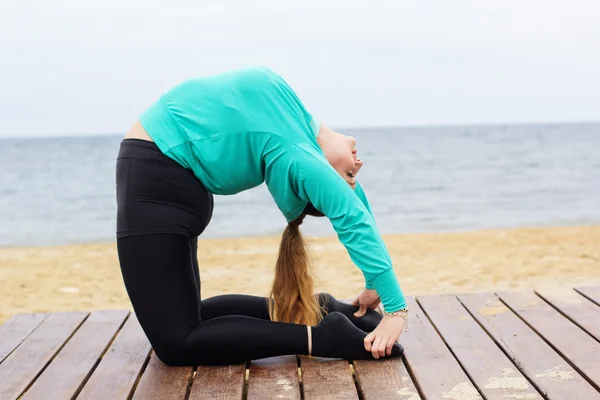 Femeia care face hatha yoga asana lângă mare — Fotografie, imagine de stoc