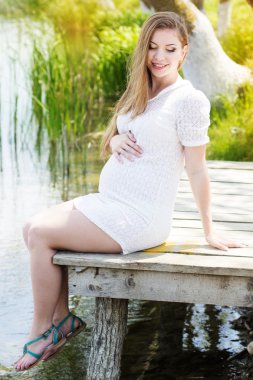 Köprü Nehri yakınında oturan hamile kadın