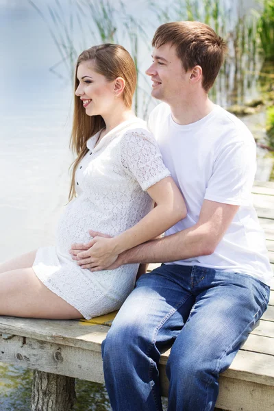 Ypung couple are sitting on bridge — Stock Photo, Image