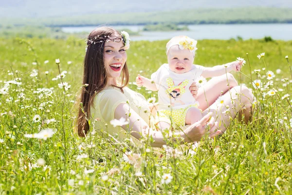 Mother and daughter on the camomile meadow — Stock Photo, Image