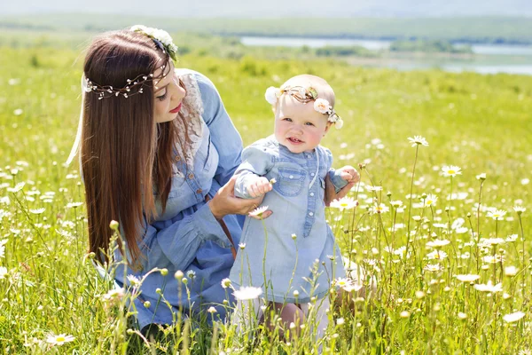 Mother with daughter on the camomile meadow — Stock Photo, Image