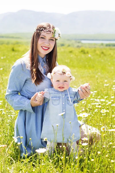 Mamma med dotter på camomile meadow — Stockfoto