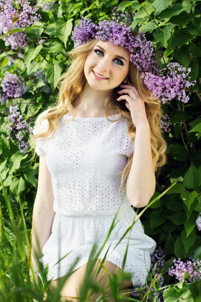 Beautiful girl with a wreath of lilac flowers — Stock Photo, Image