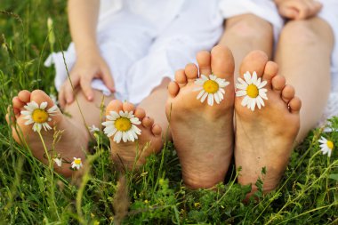 Childs feets papatya çiçekler yeşil çimenlerin üzerinde 