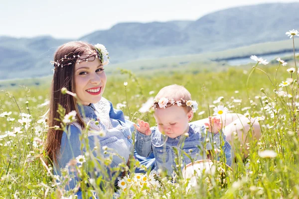 Мать с маленькой дочерью на ромашковом лугу — стоковое фото