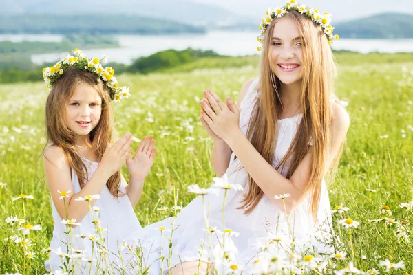 Two friends girls at meadow of chamomiles — Stock Photo, Image