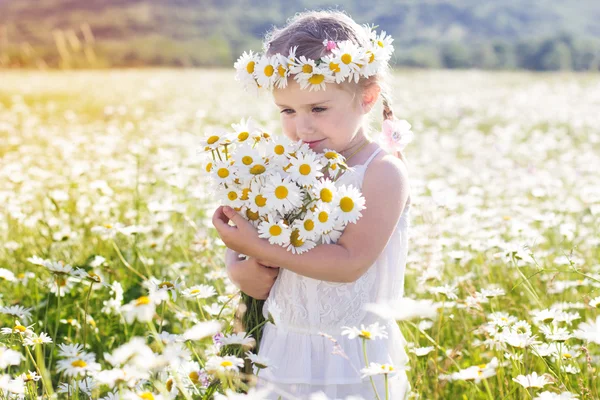 Cute little girl with bouquet of chamomiles — Stock Photo, Image