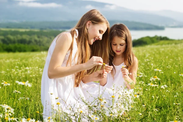 Two pretty friends girls at meadow of chamomiles — Stock Photo, Image