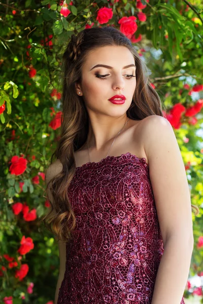 Mädchen mit roten Lippen im Rosengarten — Stockfoto