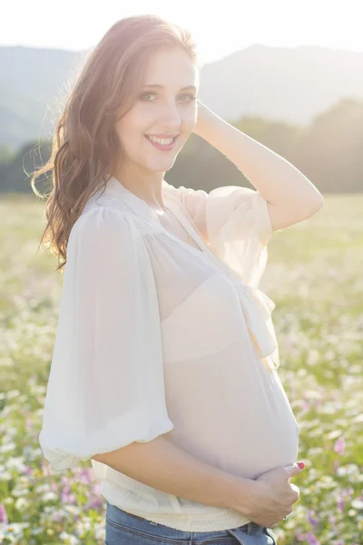 Femme enceinte dans les lumières du coucher du soleil — Photo