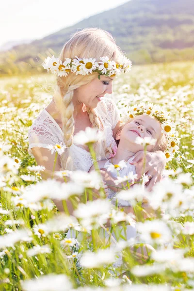 Familie moeder en kind op gebied van madeliefjebloemen — Stockfoto