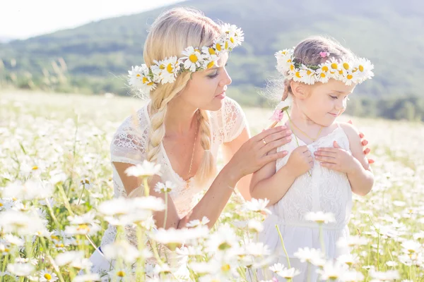 Para matki i dziecka w dziedzinie kwiaty daisy — Zdjęcie stockowe