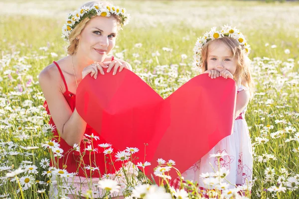 Matka a dítě se drží červené srdce — Stock fotografie