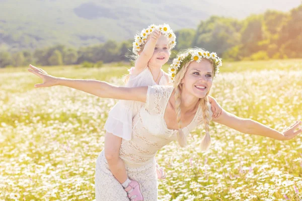 Happy family in field of daisy flowers — Stock Photo, Image