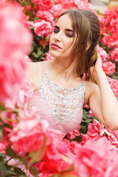 Mode porträtt av flicka nära rosa rosor — Stockfoto