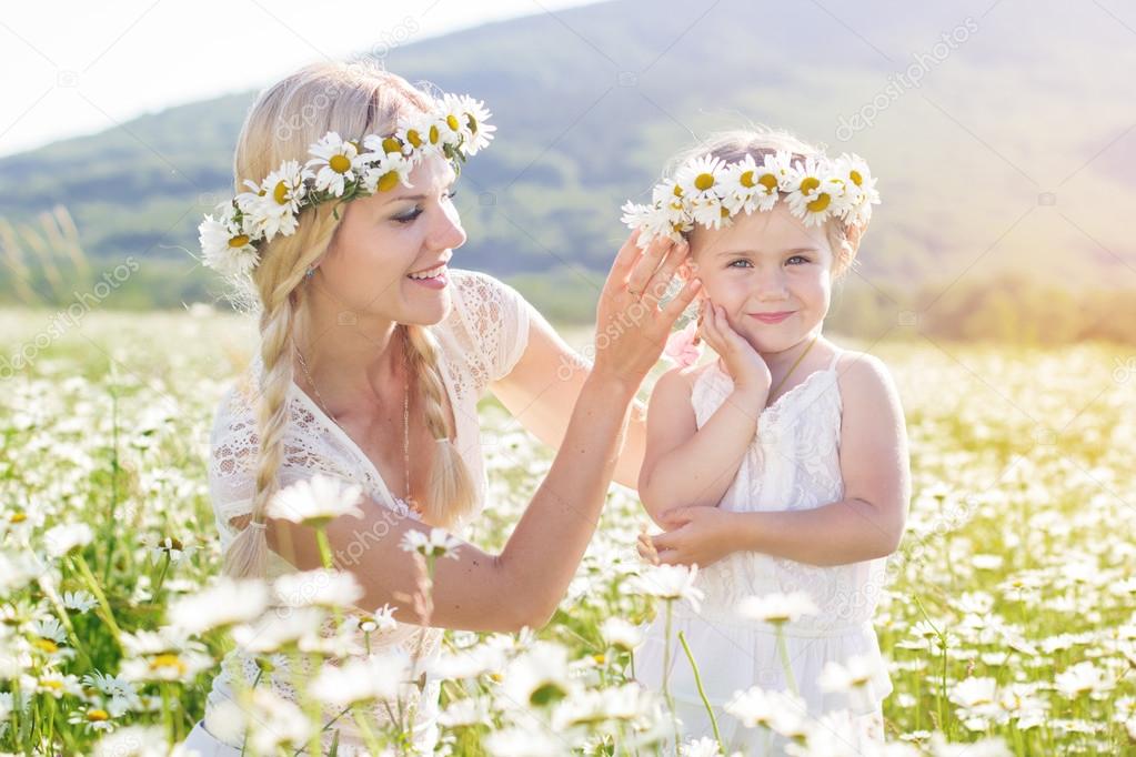 Mother and daughter in field of daisy flowers