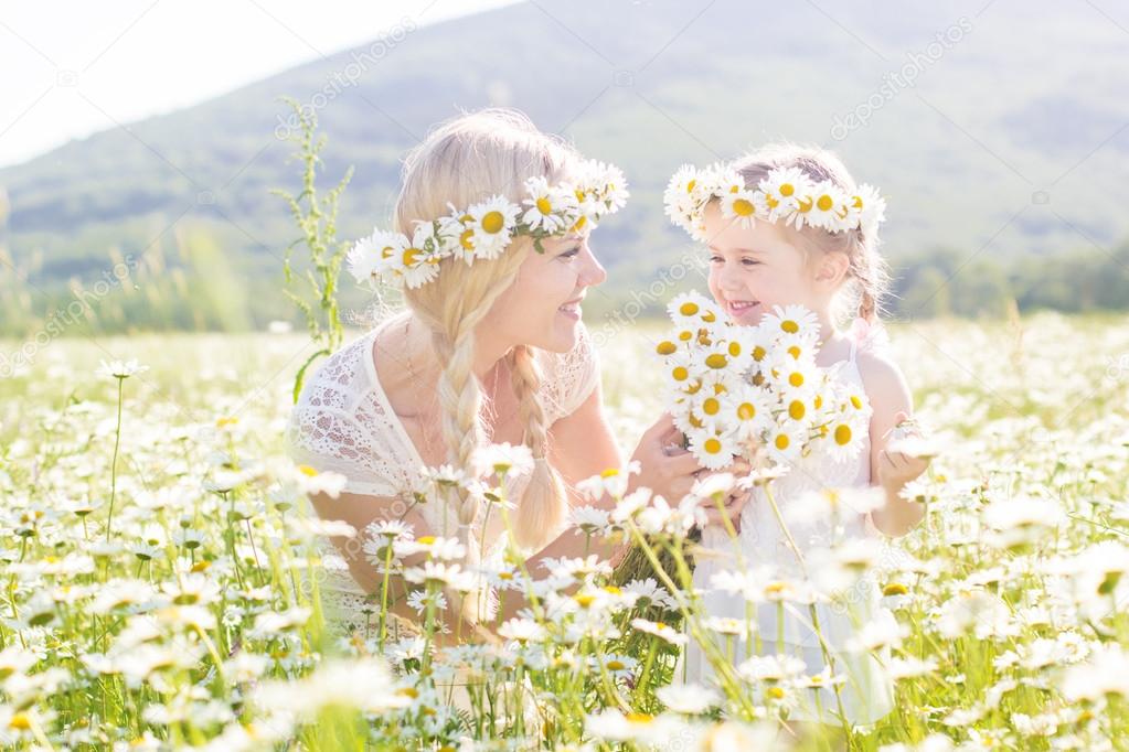 Family mother and child in field of daisy flowers