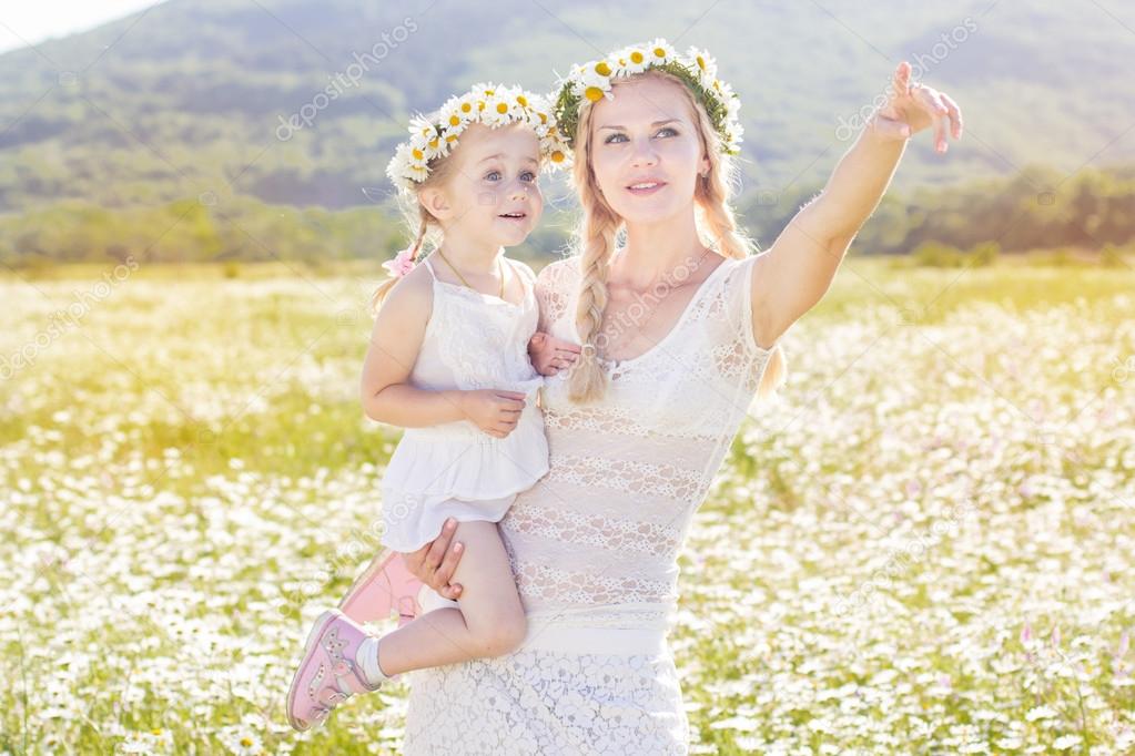 Family mother and child in field of daisy flowers