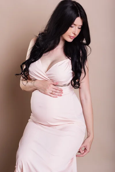 美丽的孕妇举行她的肚子里的工作室肖像 — 图库照片