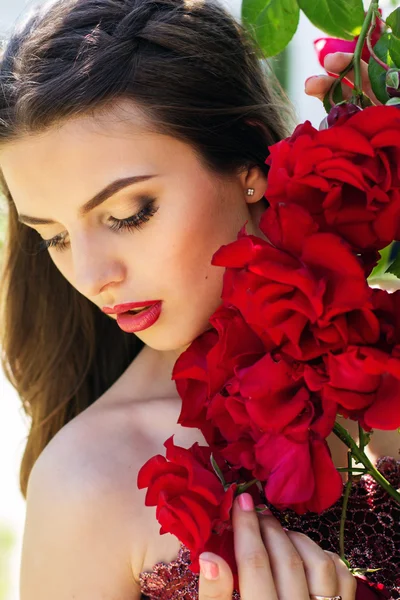 Fashion portrait of beautiful woman is posing near roses — Stock Photo, Image