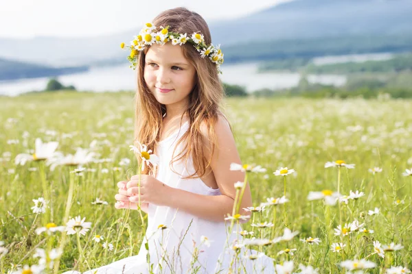 Ragazza carina bambino a camomilla campo — Foto Stock