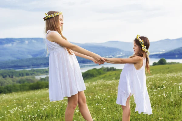Two pretty sisters at meadow with nice view — Stock Photo, Image