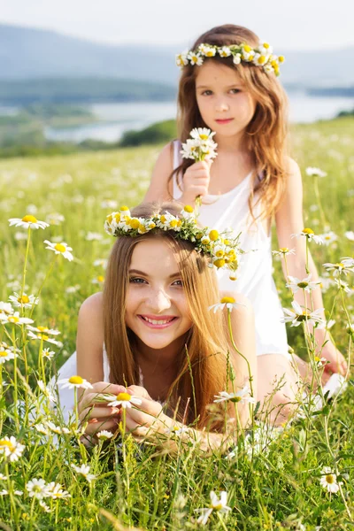 Duas meninas bonitas no prado com bela vista para a montanha — Fotografia de Stock