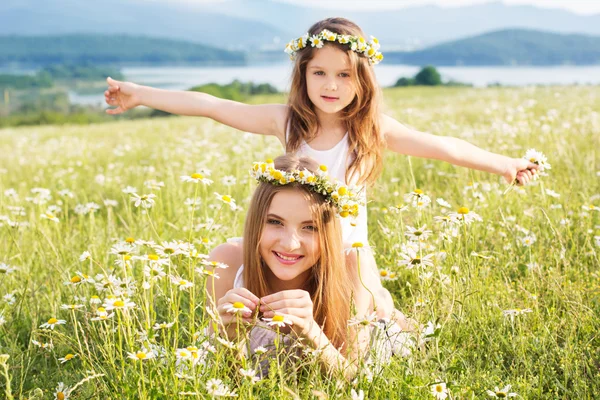 Дві красиві дівчата на лузі з гарним видом на гору — стокове фото