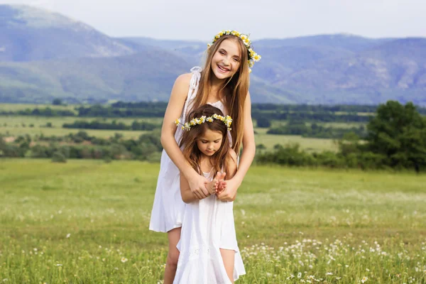 Cute girls at meadow with nice mountain view — Stock Photo, Image