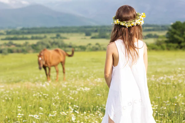 Симпатичная девочка смотрит на лошадь — стоковое фото