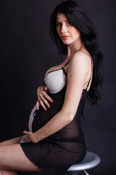 Schwangere trägt sexy schwarzes Negligé — Stockfoto