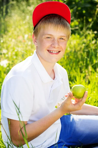 Adolescente rubia chico es holding verde manzanas — Foto de Stock