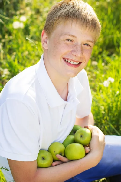 Adolescente chico es holding verde manzanas — Foto de Stock