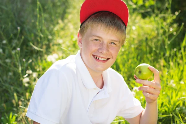 Adolescente rubia chico es holding verde manzanas — Foto de Stock